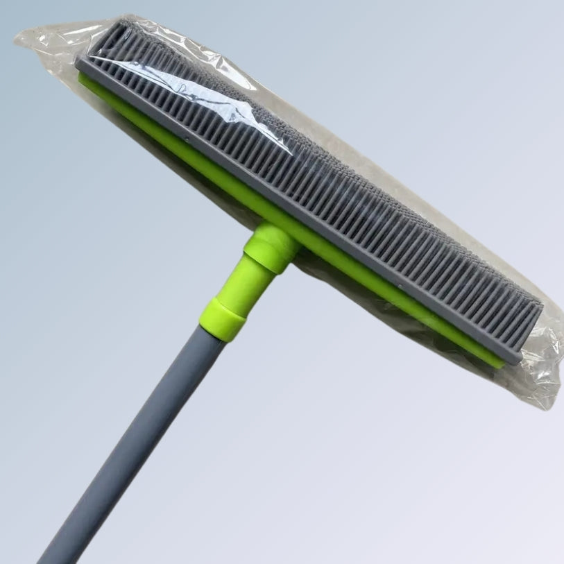 Vassoura sendo usada para limpar pelos de um sofá.